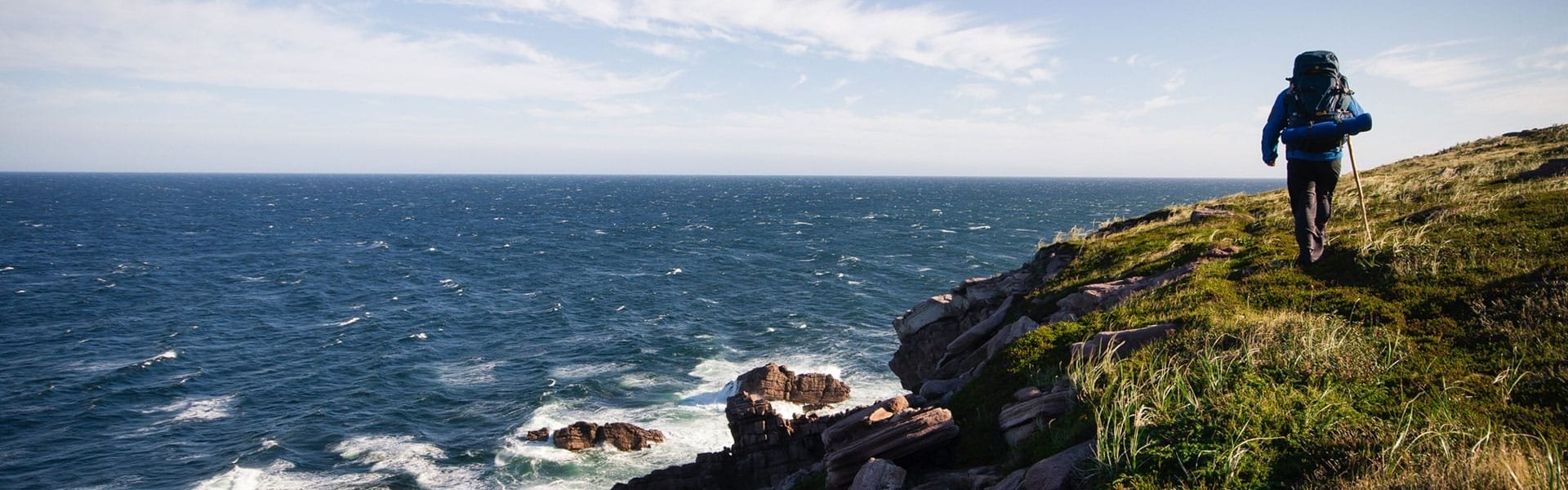 A hiker treks along the coastline