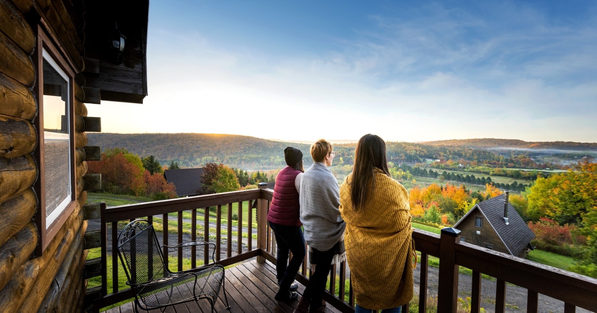 People enjoy a sunrise from the balcony of a cabin